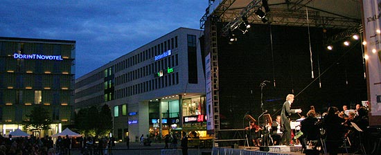 Chefdirigent Professor Johannes Goritzki und die Mendelssohn Philharmonie D&uuml;sseldorf vor den Riem Arcaden und dem Dorint Novotel Hotel in M&uuml;nchen (Foto: Martin Schmitz)