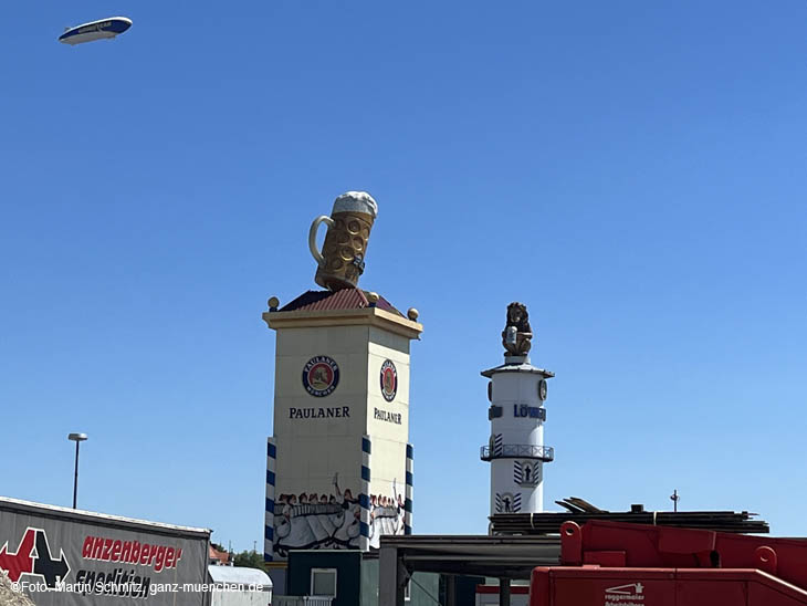 Aufbau-Arbeiten auf der Theresienwiese 03.07.2022: Zeppelin über dem Paulaner Turm und Löwenbräu Turm (©Foto: Martin Schmitz)