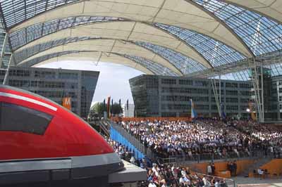 2.500 Festakts-Teilnehmer im Hintergrund blicken auf ein Model des diskutierten Transrapids, der den Münchner Hauptbahnhof einmal mit dem Münchner Flughafen verbinden könnte. Ob dafür Geld aufgetrieben werden kann? (Foto: Martin Schmitz)